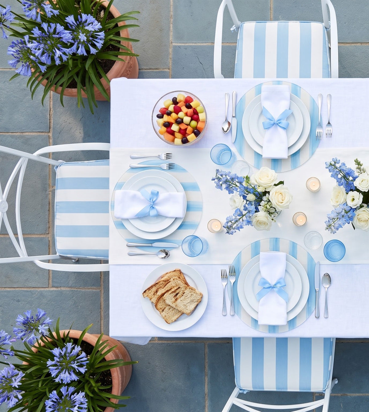 Sky Blue and White Striped placemats on a laid table, seen from above